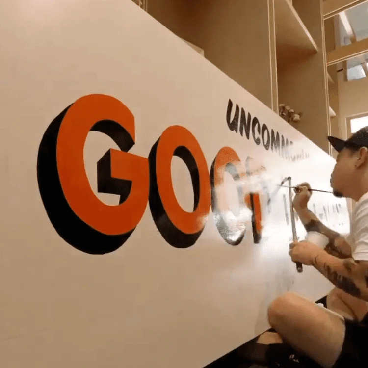 EJ hand-painting large lettering for Common Man Coffee Roasters