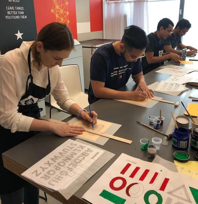Participants practising lettering together at a workshop